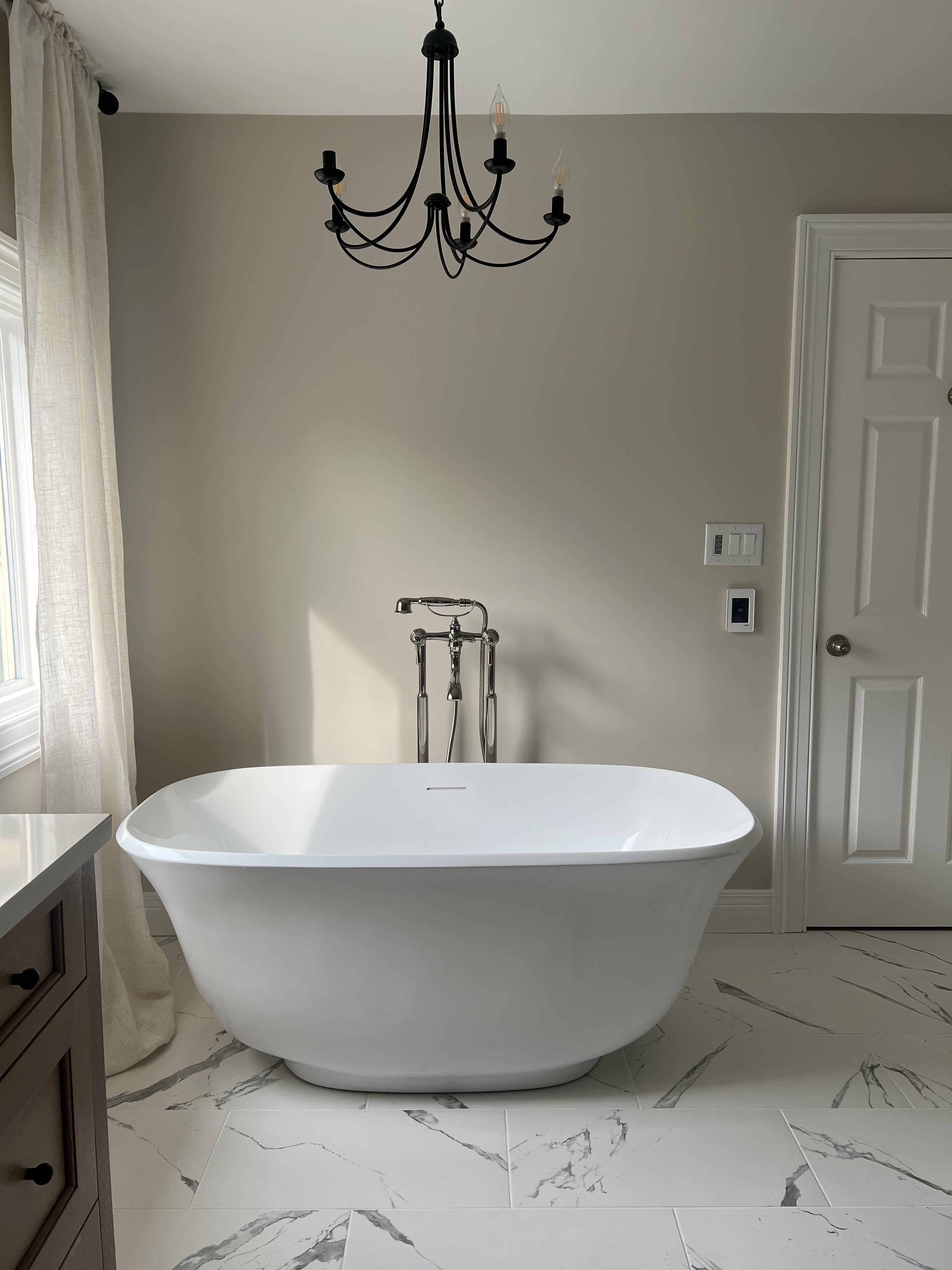 Rolling Hills bathroom — freestanding soaking tub with floor-mount faucet and chandelier by Luxe Built
